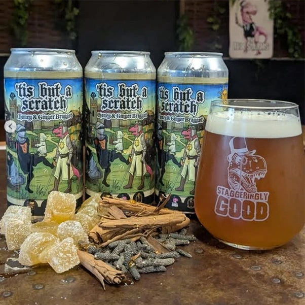 Cans of 'Tis But A Scratch with a small pile of spices used to make the braggot.