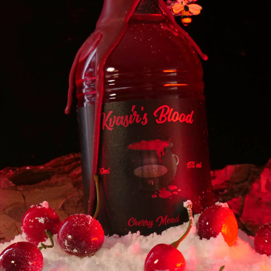 A bottle of Kvasir's Blood, sat in snow and surrounded by cherries