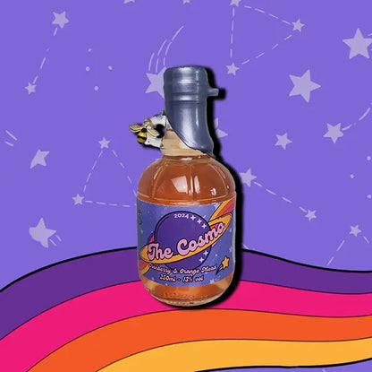 A mini 250ml bottle of The Cosmo Mead. A wax dipped bottle with a label. A small bee charm hangs from the finger handle on the bottle.
