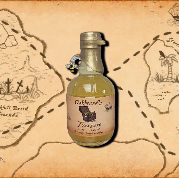 A mini 250ml bottle of The Cosmo Mead. A wax dipped bottle with a label. A small bee charm hangs from the finger handle on the bottle.