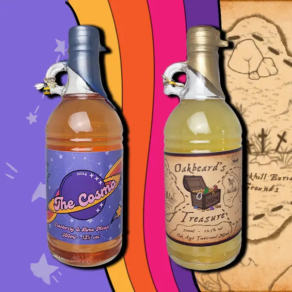 A two 500ml bottles mead. The first is a bottle of Oakbeard's Treasure. The second is a bottle of The Cosmo. Each bottle is wax dipped with a label. A small bee charm hangs from the finger handle on the bottles.