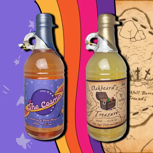 A two 500ml bottles mead. The first is a bottle of Oakbeard's Treasure. The second is a bottle of The Cosmo. Each bottle is wax dipped with a label. A small bee charm hangs from the finger handle on the bottles.