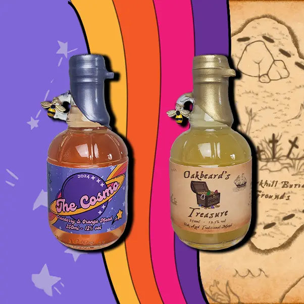A two mini 250ml bottles mead. The first is a bottle of Oakbeard's Treasure. The second is a bottle of The Cosmo. Each bottle is wax dipped with a label. A small bee charm hangs from the finger handle on the bottles.